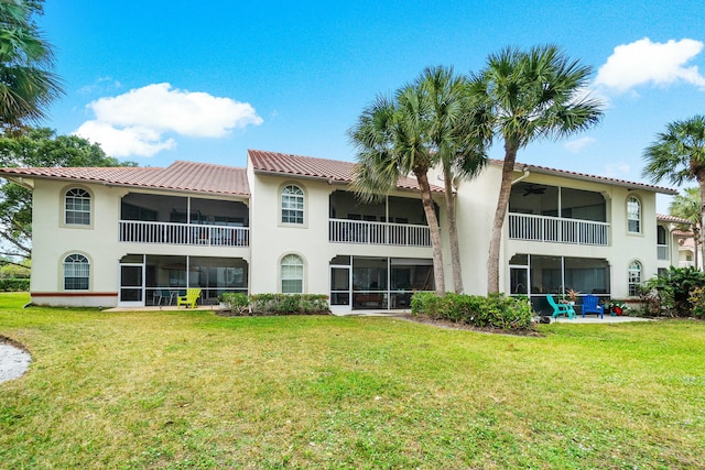 rear view of property featuring a lawn