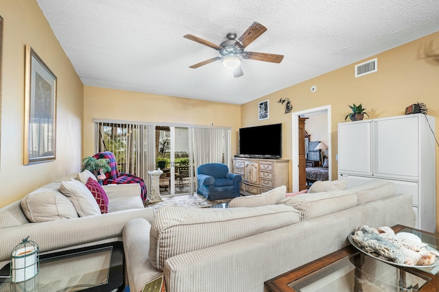 living room featuring ceiling fan and a textured ceiling