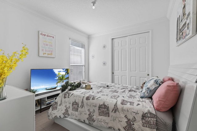 bedroom with a textured ceiling, a closet, and crown molding