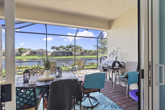 sunroom / solarium featuring a water view