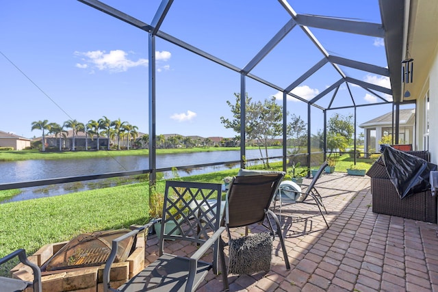 view of patio featuring glass enclosure and a water view