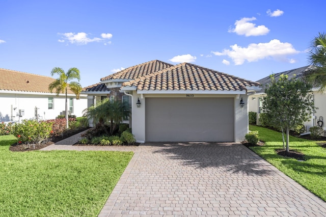 mediterranean / spanish house featuring a front yard and a garage