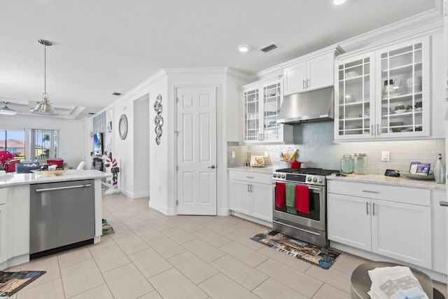 kitchen with light stone countertops, stainless steel appliances, backsplash, crown molding, and white cabinets