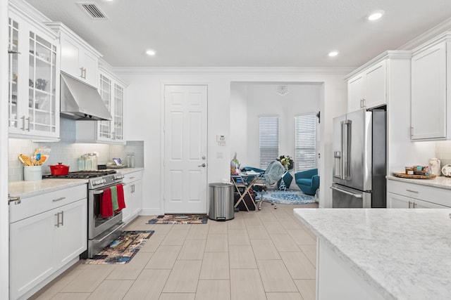 kitchen with white cabinets, light stone countertops, backsplash, and appliances with stainless steel finishes