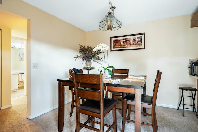 carpeted dining space featuring a chandelier