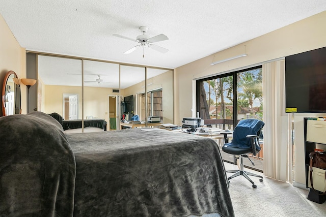 bedroom featuring ceiling fan, light colored carpet, a textured ceiling, and a closet