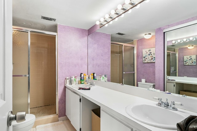 bathroom with tile patterned flooring, toilet, an enclosed shower, and vanity