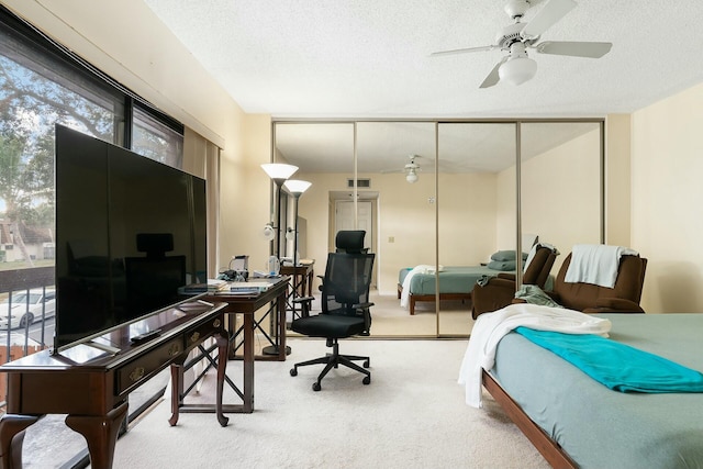 bedroom featuring carpet flooring, a textured ceiling, a closet, and ceiling fan