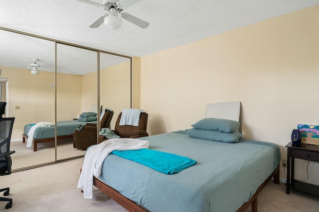 bedroom with a textured ceiling, carpet floors, a closet, and ceiling fan