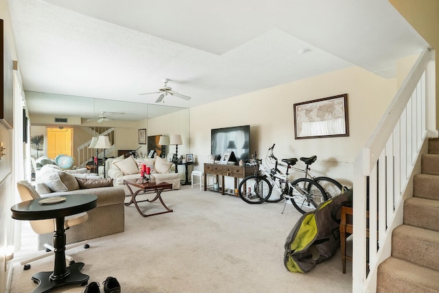 living room featuring carpet flooring, ceiling fan, and a textured ceiling