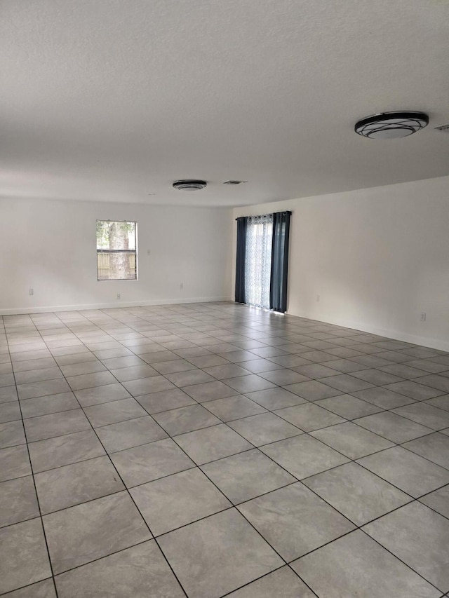 empty room featuring light tile patterned floors and a textured ceiling