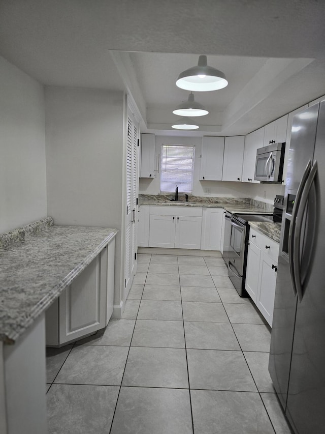 kitchen featuring light stone counters, stainless steel appliances, sink, light tile patterned floors, and white cabinets