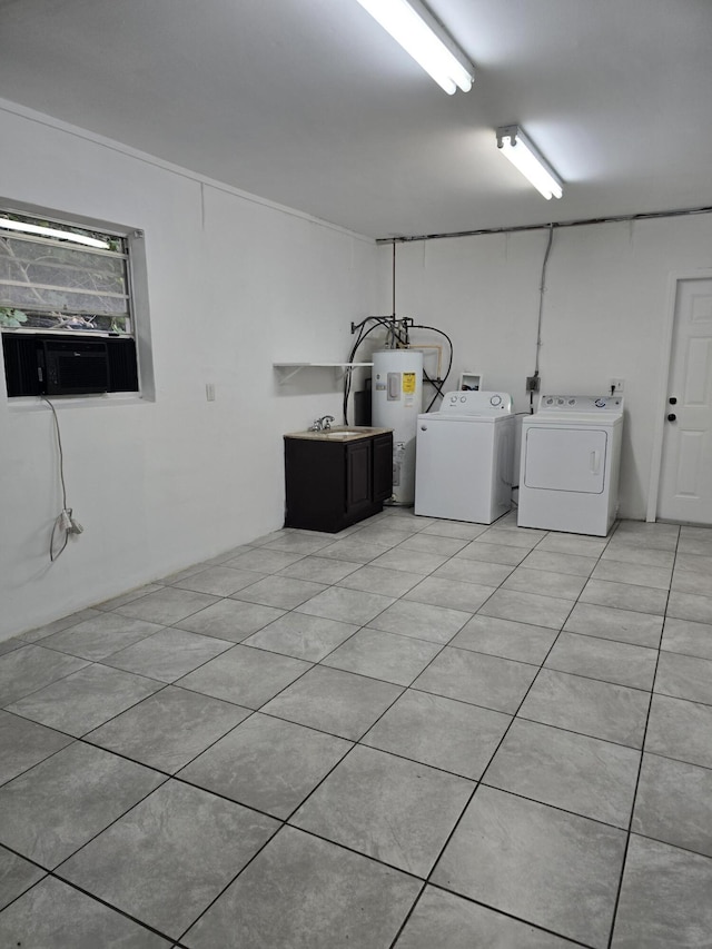 laundry room with light tile patterned flooring, washing machine and dryer, and water heater