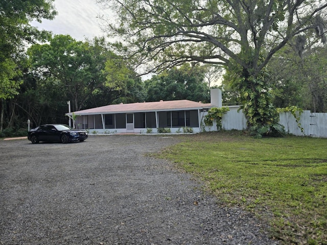 view of front of home featuring a sunroom and a front lawn