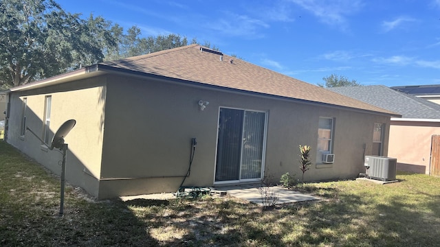 rear view of house with central AC, a patio area, and a yard