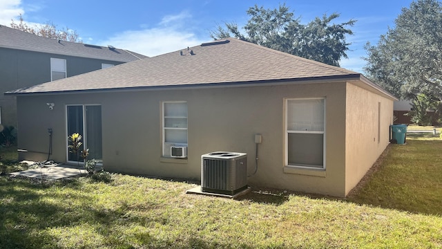 back of house with central AC and a lawn