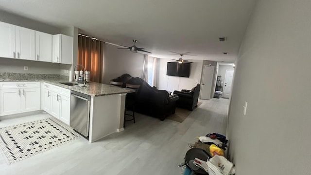 kitchen featuring dishwasher, sink, kitchen peninsula, light hardwood / wood-style flooring, and white cabinetry