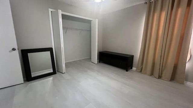 unfurnished bedroom featuring a closet and light hardwood / wood-style floors