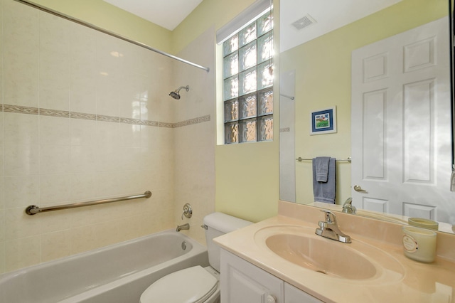 full bathroom with tiled shower / bath, vanity, and toilet