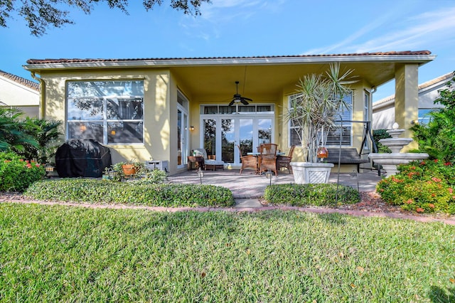 rear view of property with a yard, a patio area, ceiling fan, and french doors