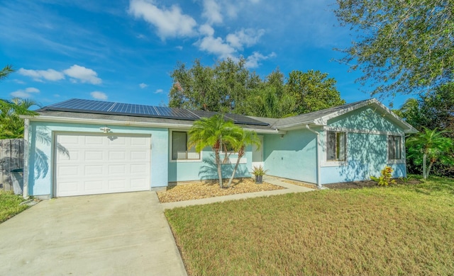 ranch-style house with solar panels, a garage, and a front lawn