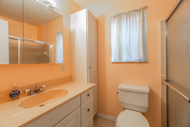 bathroom featuring tile patterned flooring, vanity, a shower with door, and toilet