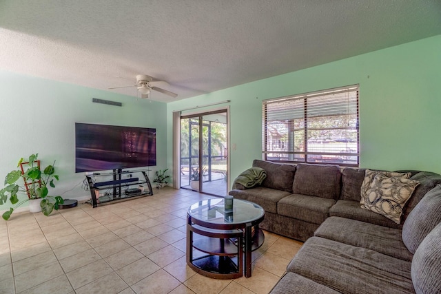 tiled living room featuring ceiling fan and a textured ceiling