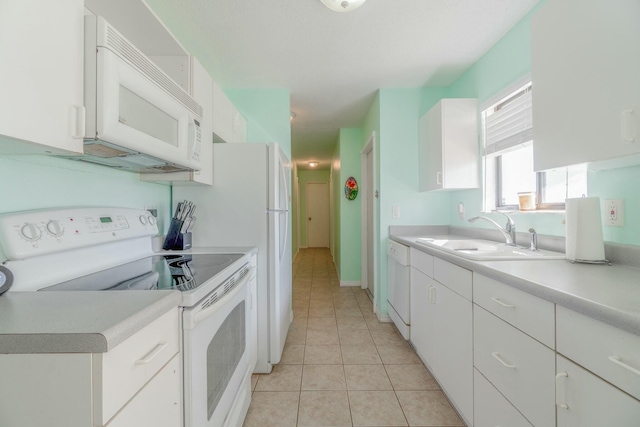 kitchen featuring white cabinets, light tile patterned flooring, white appliances, and sink