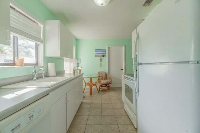 kitchen featuring light tile patterned floors, white appliances, white cabinetry, and sink