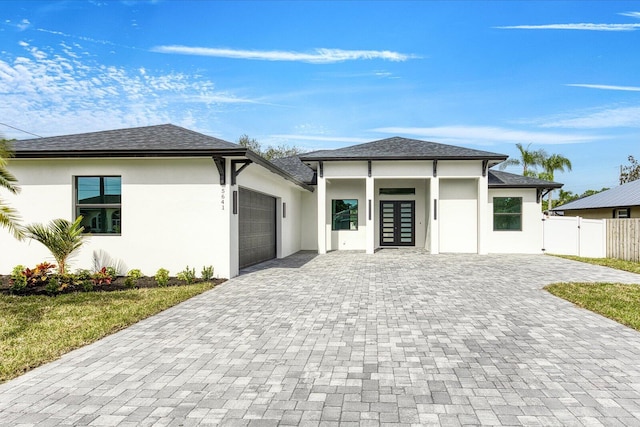 prairie-style house featuring a garage and french doors