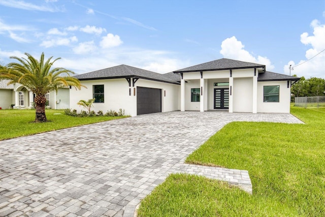 prairie-style house featuring french doors, a garage, and a front lawn