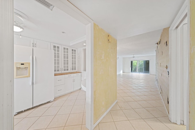 kitchen featuring ceiling fan, white cabinetry, white refrigerator with ice dispenser, and light tile patterned floors