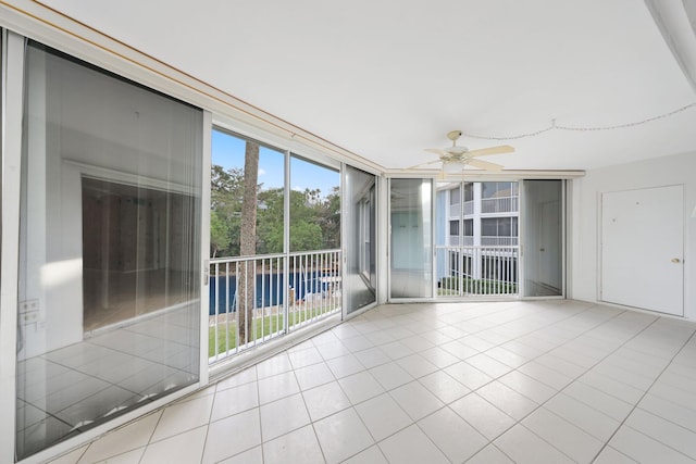 unfurnished sunroom with ceiling fan