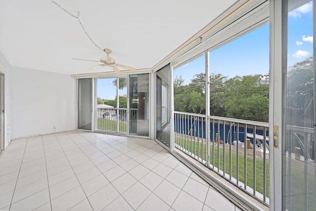 unfurnished sunroom with ceiling fan