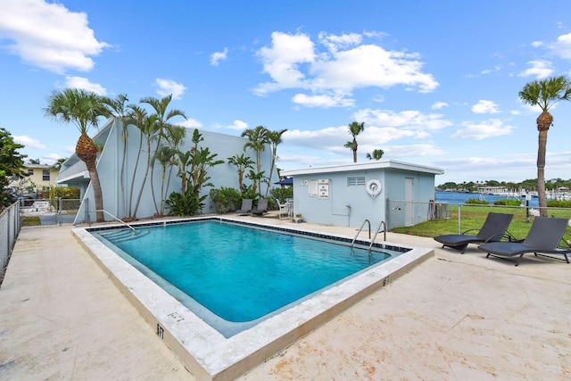 view of swimming pool featuring a water view and a patio