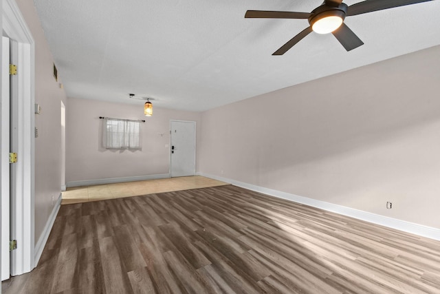 unfurnished living room featuring hardwood / wood-style flooring, ceiling fan, and a textured ceiling