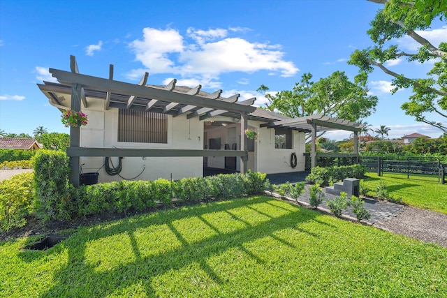 rear view of property featuring a lawn and a pergola