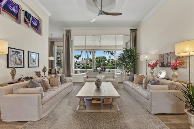 living room with hardwood / wood-style flooring, ceiling fan, and ornamental molding