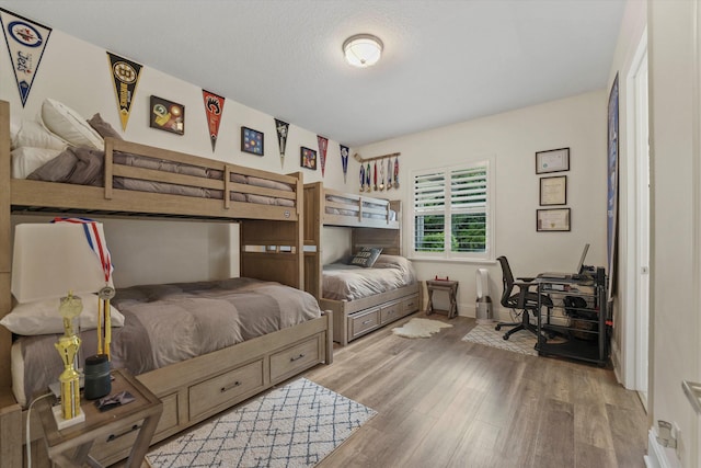 bedroom with hardwood / wood-style floors and a textured ceiling