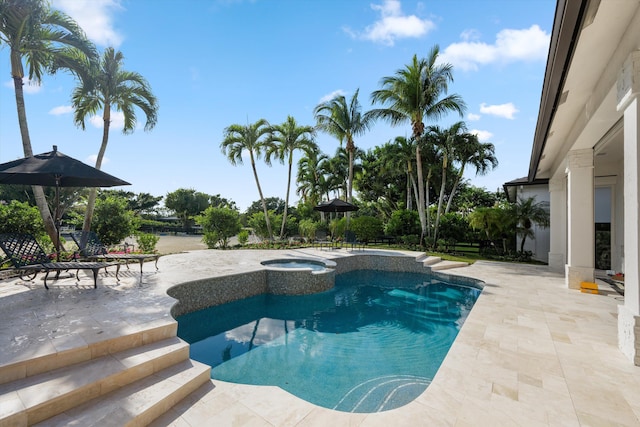 view of swimming pool featuring a patio area and an in ground hot tub