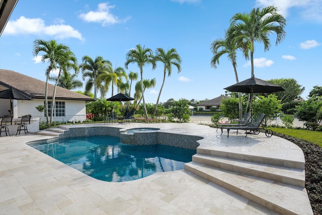 view of swimming pool featuring an in ground hot tub and a patio