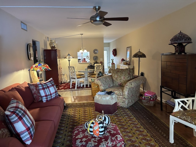 living room with dark hardwood / wood-style floors and ceiling fan with notable chandelier