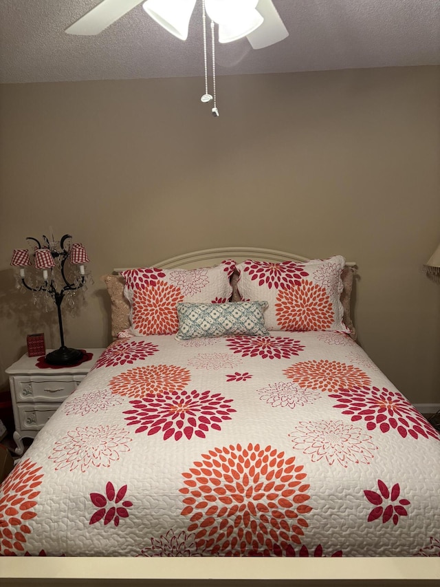 bedroom with ceiling fan and a textured ceiling