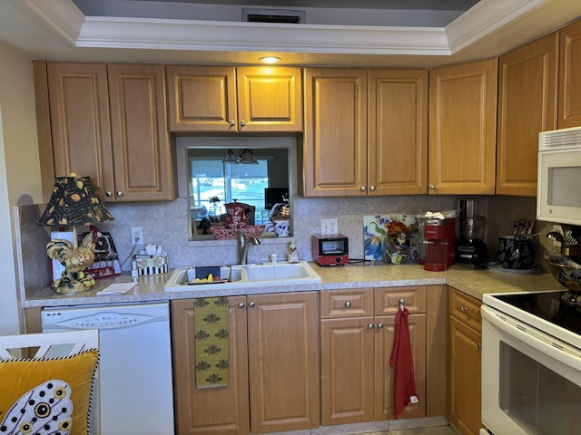 kitchen with sink, backsplash, white appliances, a tray ceiling, and ornamental molding