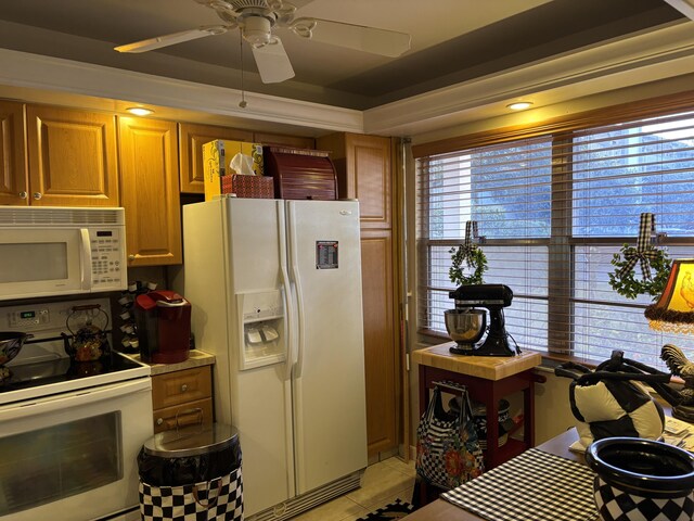 kitchen with ceiling fan, white appliances, light tile patterned floors, and a tray ceiling