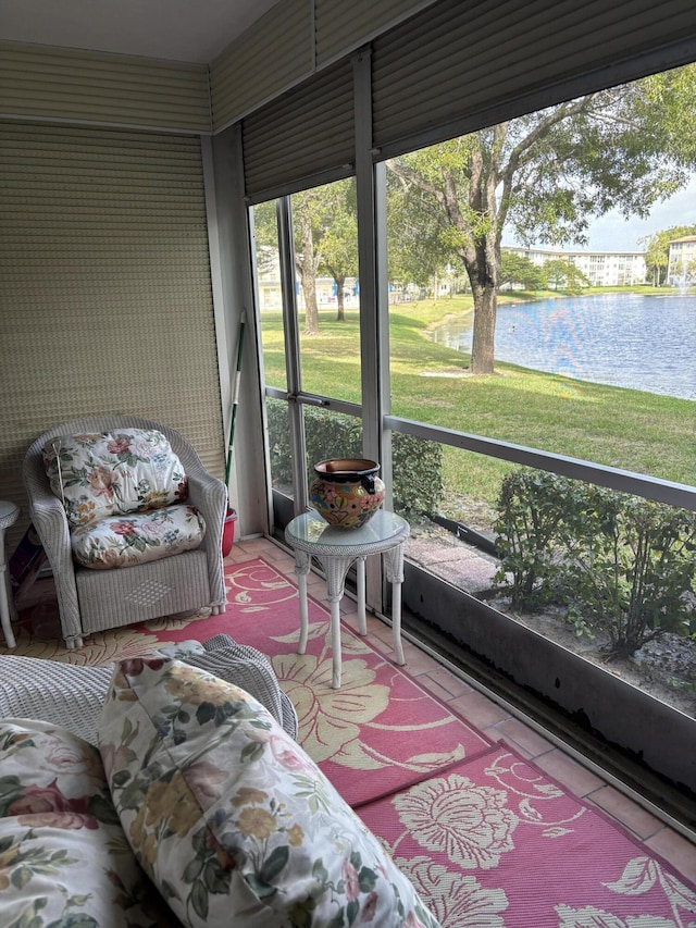 sunroom featuring a water view