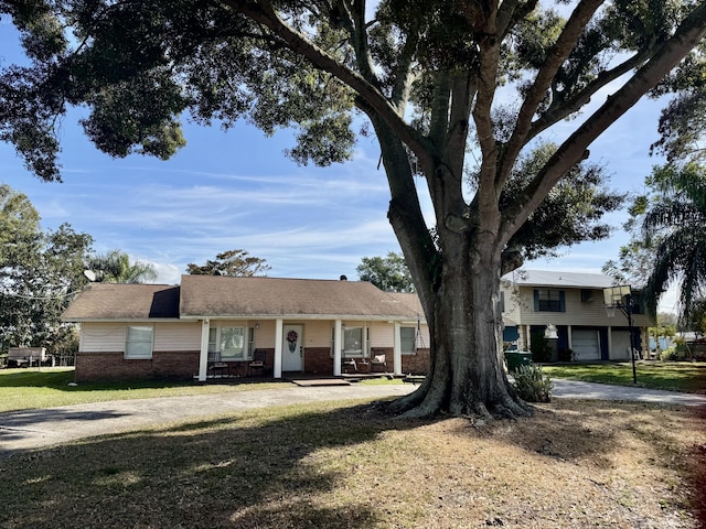 view of front of property featuring driveway, a front lawn, and brick siding