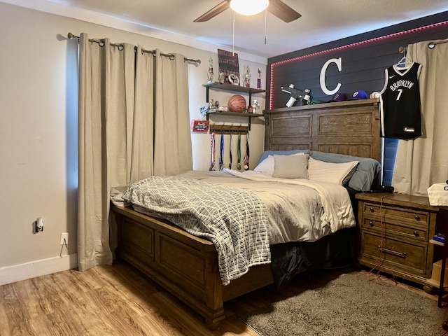 bedroom with light wood-type flooring, ceiling fan, and baseboards