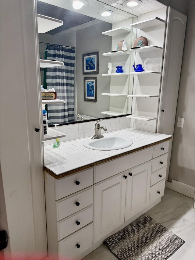 full bath with marble finish floor, backsplash, and vanity