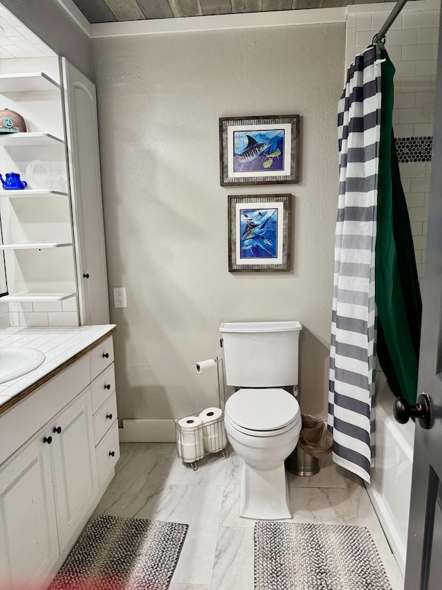 bathroom featuring marble finish floor, toilet, shower / bath combo, vanity, and baseboards